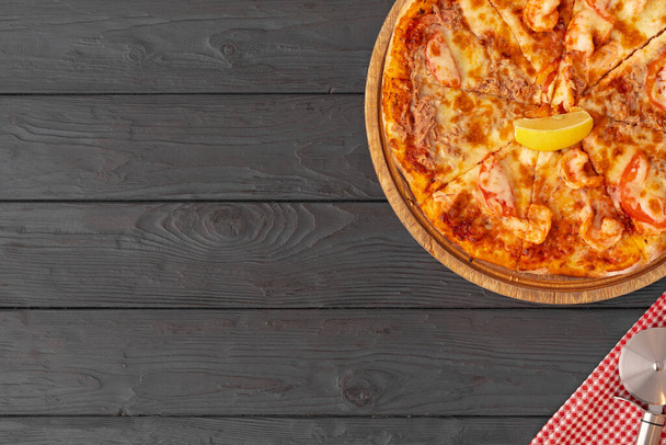 Top view of hot pizza on black wooden table - Photo, Image