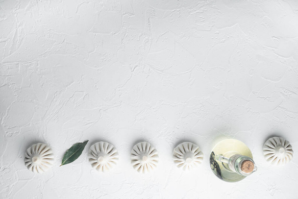 Oezbeekse Manti. Manti of manty dumplings, populaire Oezbeeks-aziatische schotel set, op wit stenige ondergrond, bovenaanzicht vlak, met kopieerruimte voor tekst - Foto, afbeelding