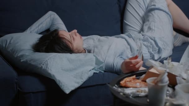 Δυστυχισμένη καταθλιπτική γυναίκα ξαπλωμένη στον καναπέ να φαίνεται χαμένη στο βρώμικο τραπέζι - Πλάνα, βίντεο