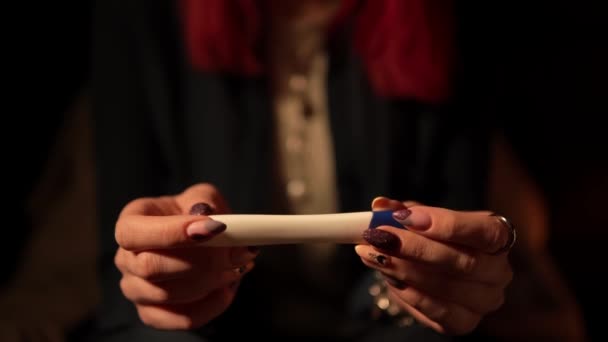 Makrofilm z kobiecymi rękami z testem ciążowym i czekającymi na wyniki - Materiał filmowy, wideo