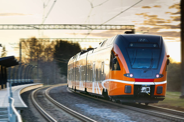 Ekspresowy pociąg pomarańczowy. Estoński nowy pociąg. Szybkie światło Intercity i pociąg regionalny. ekologiczny transport pasażerski - Zdjęcie, obraz