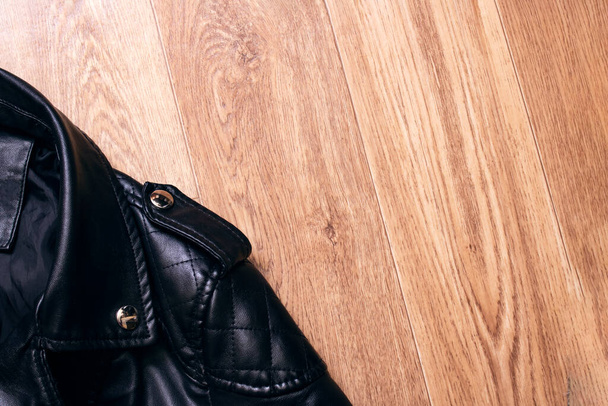 Μαύρο δερμάτινο μπουφάν σε ξύλινο φόντο αντίγραφο χώρου - Φωτογραφία, εικόνα
