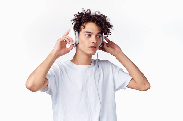 kudrnatý chlap ve sluchátkách poslouchá hudbu emoce zábava - Fotografie, Obrázek