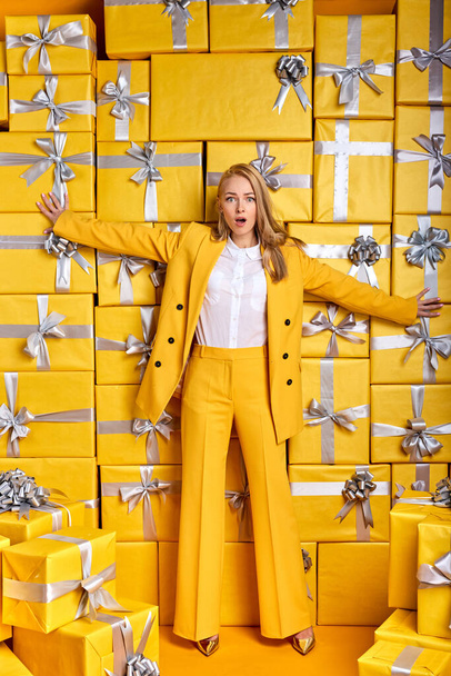 blonde lady in stylish elegant outfit is surprised by seeing so many gifts present boxes - Фото, зображення