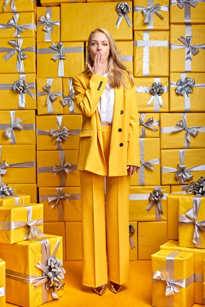 blonde lady in stylish elegant outfit is surprised by seeing so many gifts present boxes - Φωτογραφία, εικόνα