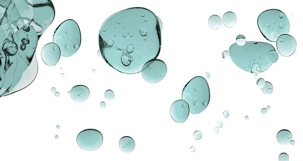 Textura cosmética de gel líquido. Gotas de gel azul verdoso. Primer plano del producto cosmético transparente aislado sobre fondo blanco. - Foto, Imagen