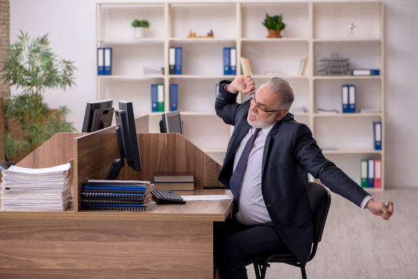 Старый работодатель-мужчина и слишком много работы в офисе - Фото, изображение