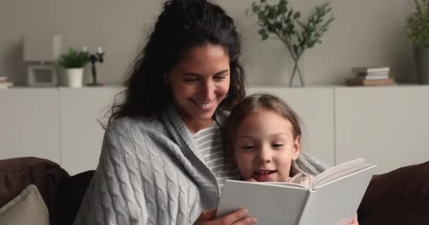 Happy bonding young mother reading book to daughter. - Video, Çekim