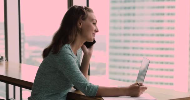 Female talk on phone with client specifying details fills document - Video, Çekim