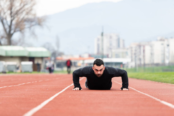 Handsome Young Man Doing Pushups on a Track - Foto, Bild