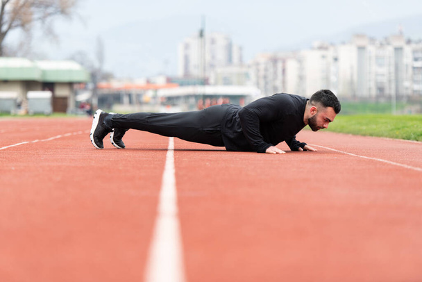 Handsome Young Man Doing Pushups on a Track - Foto, immagini