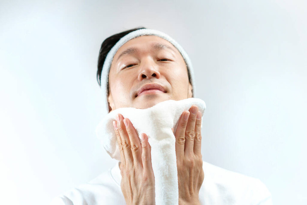 Japanese middle-aged man wiping his face with a towel  - Photo, Image