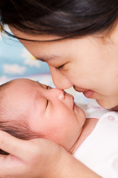 азіатська мати цілує її сплячий дитина хлопчик
 - Фото, зображення