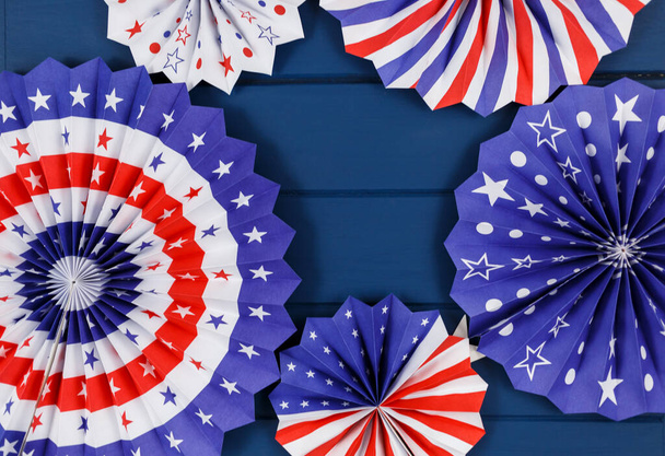Decoraties voor de 4 juli dag van de Amerikaanse onafhankelijkheid, vlag, kaarsen, rietjes, papier fans. USA vakantie decoraties op een blauwe achtergrond, bovenaanzicht, platte lay - Foto, afbeelding