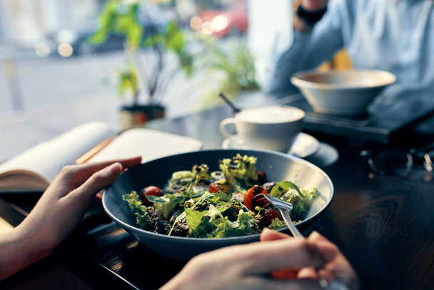herkullinen ruoka salaatti lautasella haarukka muistilehtiö kirjoitus ja nainen paita kahvila sisustus - Valokuva, kuva