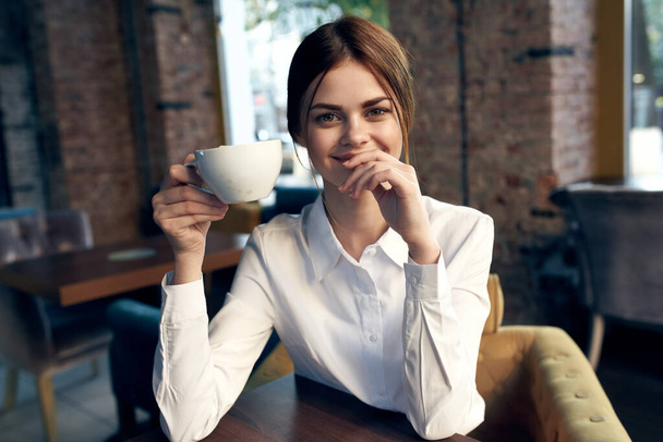 donna seduta in un caffè a tavola una tazza di stile di vita bere - Foto, immagini