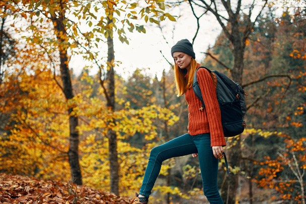 szczęśliwa kobieta turysta z plecakiem na plecach w jesiennym lesie - Zdjęcie, obraz