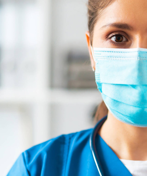 Профессиональный врач, работающий в больничном кабинете, Портрет молодой и привлекательной женщины-врача в защитной маске. - Фото, изображение