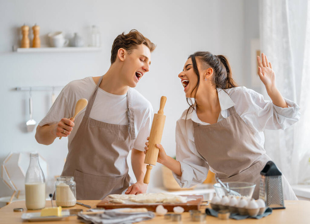 Happy loving couple is preparing the pastry in the kitchen. - Фото, зображення
