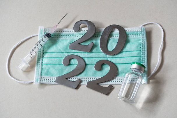 2022 com máscara facial, seringa e frasco para injetáveis de vacina - Foto, Imagem