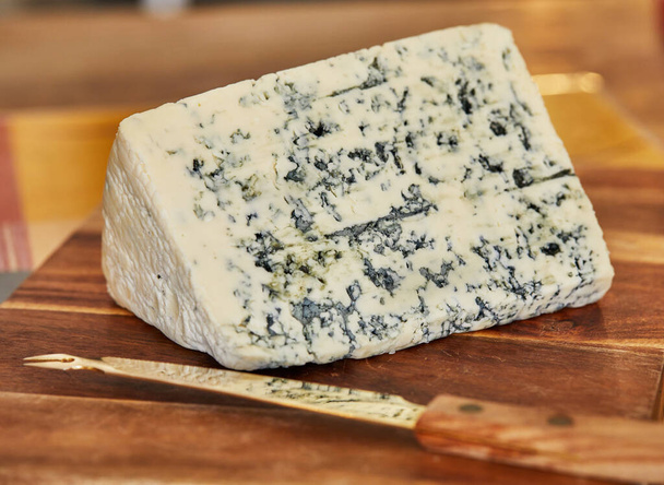 Vybraný francouzský modrý sýr, dor blue na dřevěné desce a nůž na sýr - Fotografie, Obrázek