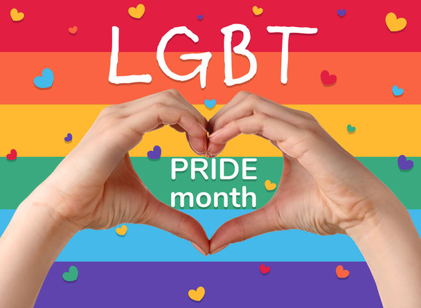 Hands making heart and text LGBT PRIDE MONTH on rainbow background - Photo, Image