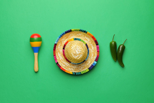 Mexican sombrero, maracas and chili peppers on color background - Foto, Imagen
