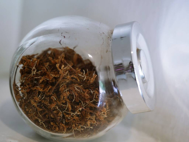 Le foglie di tè essiccate sono ben tenute in un vaso. - Foto, immagini