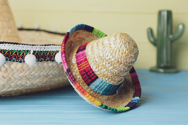 Mexican sombreros and ceramic cactus on color background, closeup - Foto, Imagen