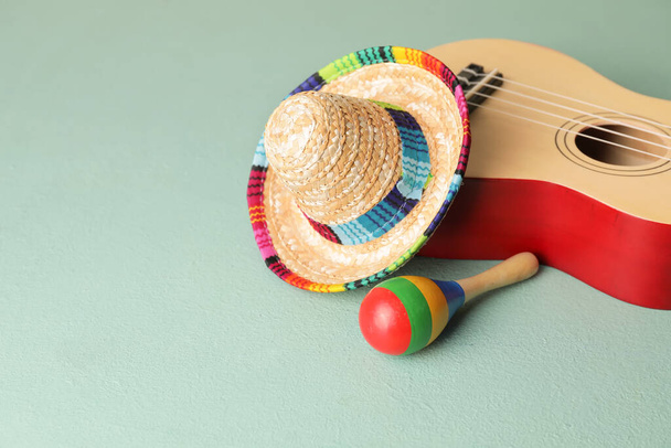Mexican sombrero, guitar and maracas on color background - Photo, Image