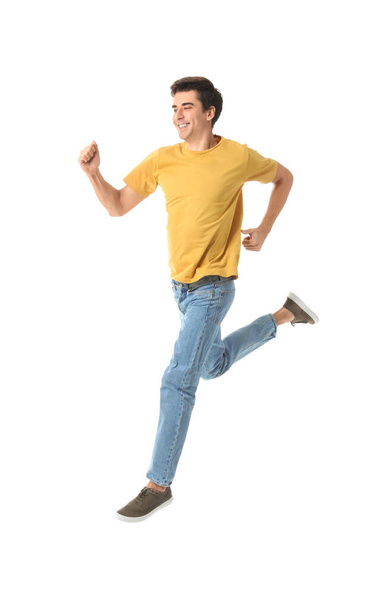 Jumping young man on white background - Fotoğraf, Görsel