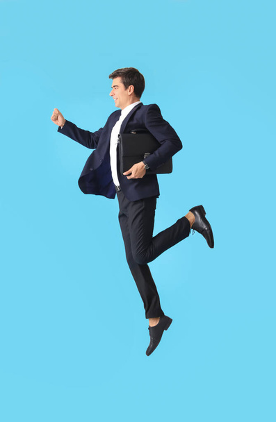 Jumping man with briefcase on color background - Foto, Imagem