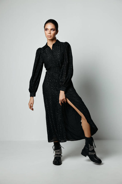 красивая брюнетка в черном платье и сапогах мода современный стиль - Фото, изображение