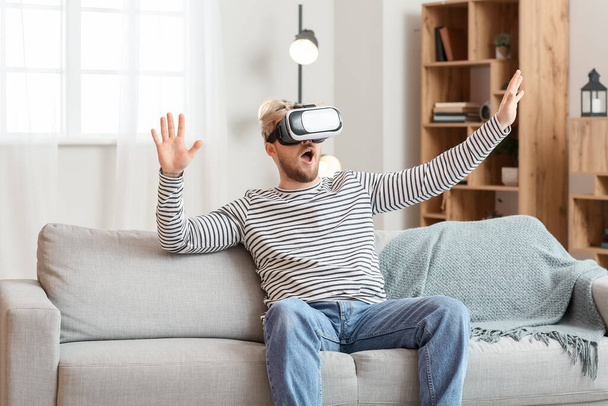 Young man with VR glasses at home - Fotoğraf, Görsel