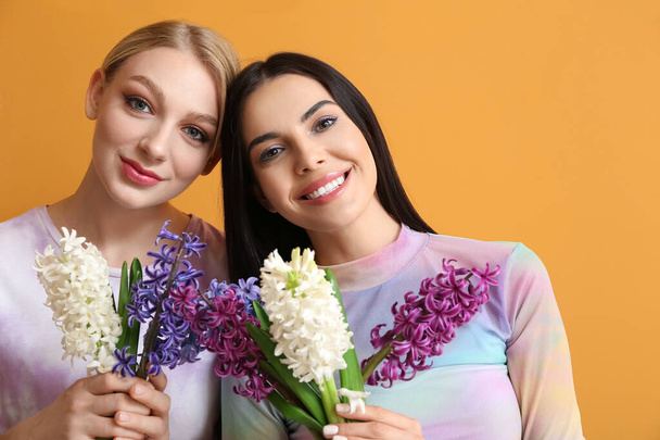 Arka planda sümbül çiçekleri olan güzel genç kadınlar. - Fotoğraf, Görsel