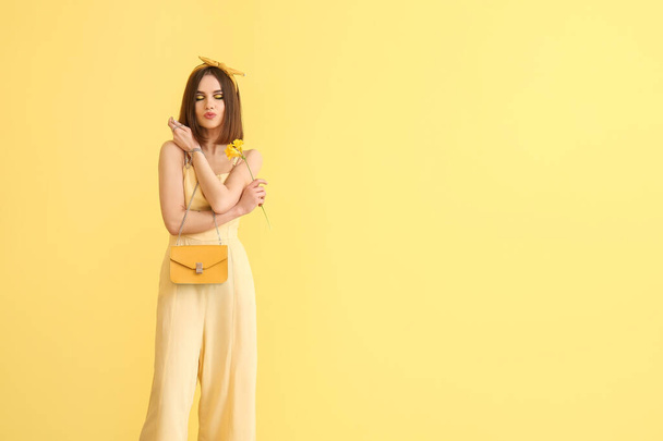 Mujer joven con estilo sobre fondo amarillo - Foto, imagen