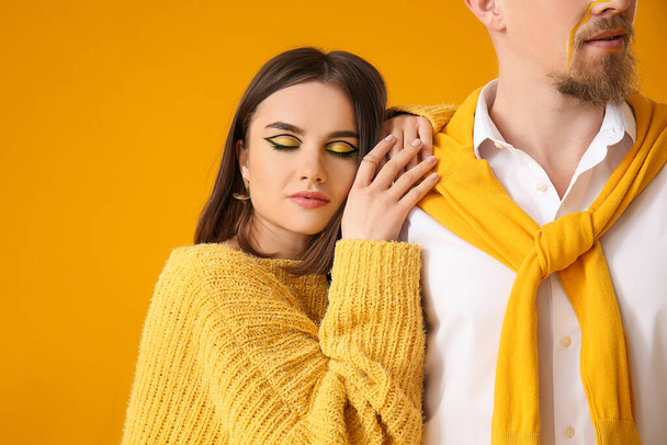 Stylish young couple on yellow background - Photo, Image