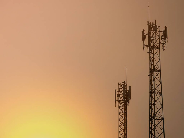 Τηλεφωνούντες πύργοι που εκπέμπουν σήματα το σούρουπο. - Φωτογραφία, εικόνα