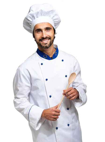 Portrait of a confident chef holding wooden spoon isolated on white background - Фото, изображение