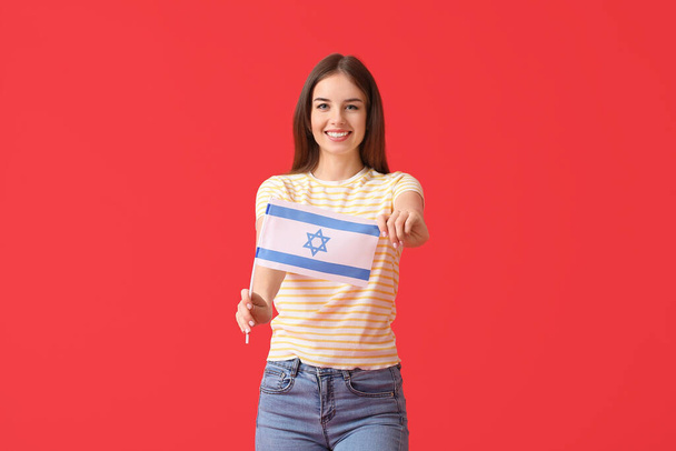 Young woman with the flag of Israel on color background - Fotó, kép