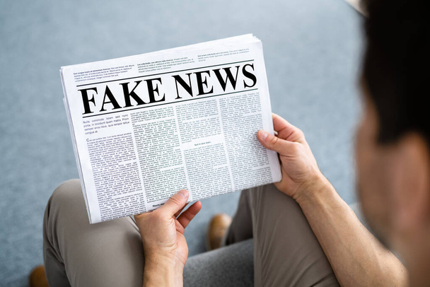 Businessman Reading Fake News Article On Newspaper In Living Room - Foto, afbeelding
