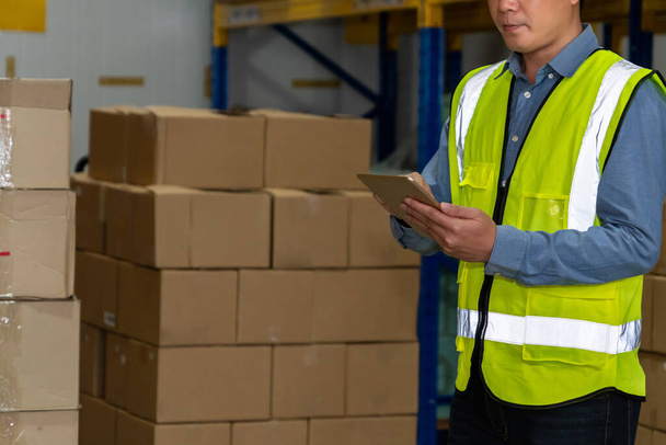Asian warehouse worker checking packages in storehouse - Foto, Bild