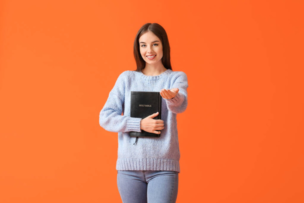 Jeune femme avec la Bible sur fond de couleur - Photo, image