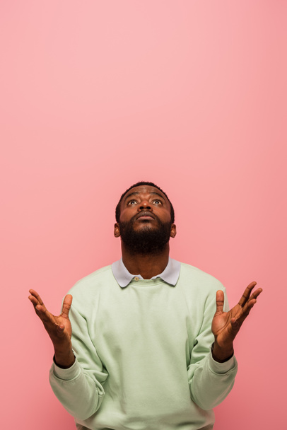 African american man looking up isolated on pink with copy space  - Zdjęcie, obraz