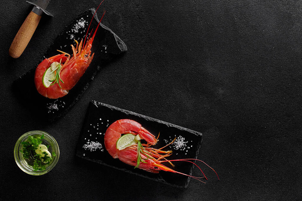 Vařené krevety s koření a krevetový nůž na černém pozadí - Fotografie, Obrázek
