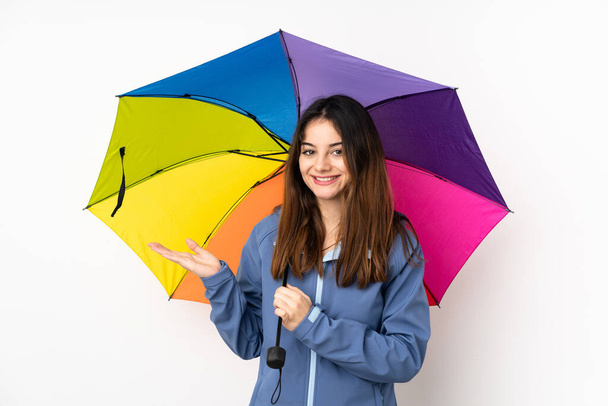 Mujer sosteniendo un paraguas aislado sobre fondo blanco sosteniendo espacio de copia imaginario en la palma - Foto, imagen