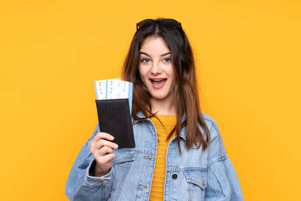 Młoda kaukaska kobieta odizolowana na żółtym tle szczęśliwa na wakacjach z paszportem i biletem lotniczym - Zdjęcie, obraz