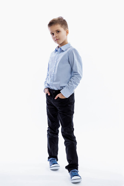 A serious boy of 7 years old is standing. Full height. White background. White background. Vertical. - Photo, image