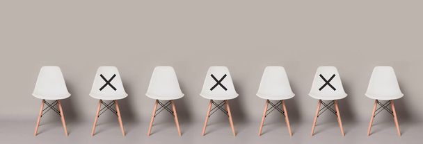 Leerer moderner weißer Stuhl Stehreihen mit Symbol auf Stuhl, um Abstand zu halten auf hellgrauer Farbe Banner Größe Hintergrund mit Kopierraum., Protective Coronavirus (COVID-19) Konzept - Foto, Bild
