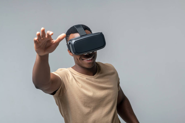 Smiling man in VR glasses waving his hands - Fotografie, Obrázek